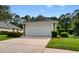 Close-up of a two-car garage with an extended driveway, surrounded by lush, green landscaping at 821 Laquinta Loop, Murrells Inlet, SC 29576