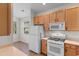 Bright kitchen features white appliances, wooden cabinets and tiled floors at 821 Laquinta Loop, Murrells Inlet, SC 29576