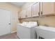 Well-equipped laundry room with washer, dryer, utility sink, and plenty of cabinet storage space above at 821 Laquinta Loop, Murrells Inlet, SC 29576