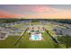 A birds eye view of homes surrounding a large pond and community pool with lush landscaping and sunset at 832 Windsor Rose Dr., Conway, SC 29526