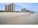 Expansive beach scene featuring multiple condo buildings and people enjoying the surf at 8560 Queensway Blvd. # 106, Myrtle Beach, SC 29572