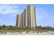 Exterior view of a high-rise condo building with multiple balconies, near the beach at 8560 Queensway Blvd. # 106, Myrtle Beach, SC 29572