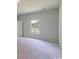 Spacious bedroom with neutral carpet, a window overlooking trees, and a white door at 863 Long Beach Dr, Longs, SC 29568