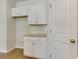 Bright kitchenette with white cabinets, granite countertop, and door at 863 Long Beach Dr, Longs, SC 29568