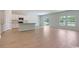 Open-concept living space featuring hardwood floors, white cabinets, and natural light streaming in from a sliding glass door at 863 Long Beach Dr, Longs, SC 29568