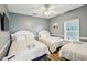 Neutral toned bedroom has three beds with fresh white linens, a ceiling fan and wood flooring at 931 S Ocean Blvd., North Myrtle Beach, SC 29582