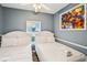 Cozy bedroom featuring two twin beds, hardwood floors, fresh linens, and a bright decorative window at 931 S Ocean Blvd., North Myrtle Beach, SC 29582
