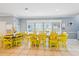 Bright and airy dining area featuring a large wooden table with vibrant yellow chairs at 931 S Ocean Blvd., North Myrtle Beach, SC 29582