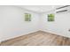 Airy bedroom featuring two windows with green views, modern A/C unit, and wood-look vinyl flooring at 1004 Georgetown St., Marion, SC 29571