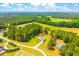 An expansive aerial view showcasing the home's location amidst a verdant landscape and mature trees at 1013 Happy Ln., Galivants Ferry, SC 29544