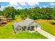 An aerial view of the home with its manicured lawn, featuring a garage, front porch, and mature trees at 1013 Happy Ln., Galivants Ferry, SC 29544