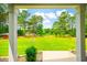 Scenic backyard view with mature trees, a large grassy area, and a white bench at 1013 Happy Ln., Galivants Ferry, SC 29544