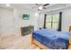 Cozy bedroom with a decorative dresser, a ceiling fan, natural lighting, and a mounted TV for relaxing at 1013 Happy Ln., Galivants Ferry, SC 29544