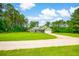 Green home situated on a large lot with a gravel driveway and mature trees, offering privacy and a serene setting at 1013 Happy Ln., Galivants Ferry, SC 29544