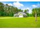 Well-maintained green home features a large front lawn, a palm tree, and mature trees in a peaceful residential setting at 1013 Happy Ln., Galivants Ferry, SC 29544