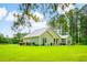 Charming green home with a metal roof, lush lawn, and mature trees offers a serene and private setting at 1013 Happy Ln., Galivants Ferry, SC 29544