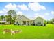 Green home with metal roof, a bench and fire pit situated on a spacious lawn surrounded by trees at 1013 Happy Ln., Galivants Ferry, SC 29544