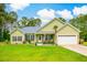 Charming single-story home with green siding, a gray metal roof, an attached garage, and a well-manicured lawn at 1013 Happy Ln., Galivants Ferry, SC 29544
