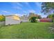 Expansive backyard with lush green grass, showcasing the house's exterior and various sheds in a serene outdoor space at 109 Plum Ln., Andrews, SC 29510