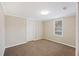 Neutral bedroom with carpet flooring, window, and white door, bathed in natural light, offering a serene space at 109 Plum Ln., Andrews, SC 29510