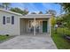 Inviting front entrance with a covered porch, seating, and a vibrant green door at 109 Plum Ln., Andrews, SC 29510