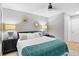 This bedroom offers soft grey walls, with a patterned throw blanket, ceiling fan, and hardwood floors at 1101 Possum Trot Rd. # D201, North Myrtle Beach, SC 29582