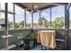 Cozy sunroom with a ceiling fan, ample natural light, and a view of trees beyond the screened windows at 1101 Possum Trot Rd. # D201, North Myrtle Beach, SC 29582