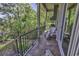 Outdoor balcony featuring black metal railings, tile floor, grill, white wood adirondack chairs, and wooded views at 1108 Surf Pointe Dr., North Myrtle Beach, SC 29582