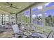 Inviting sunroom featuring large windows with waterfront views, ceiling fan, and comfortable wicker seating with table setting at 1108 Surf Pointe Dr., North Myrtle Beach, SC 29582