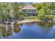 Rear exterior of a waterfront home showing lawn and retaining wall, as seen from the water at 1108 Surf Pointe Dr., North Myrtle Beach, SC 29582