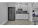 A convenient wet bar area with a stainless steel refrigerator, granite countertops, and white cabinetry at 1108 Surf Pointe Dr., North Myrtle Beach, SC 29582