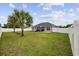 A fully fenced backyard has a large green lawn, palm trees, and a covered outdoor seating area at 1205 Cymmer Ct., Conway, SC 29527