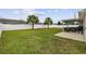 Spacious backyard featuring a covered patio with seating, two palm trees, and a well-maintained lawn with a white fence at 1205 Cymmer Ct., Conway, SC 29527