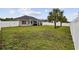 This backyard has a large green lawn, a fenced-in yard, and a covered patio with seating at 1205 Cymmer Ct., Conway, SC 29527