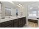 A bathroom has a double sink vanity, modern light fixtures, and a shower with white marble surround at 1205 Cymmer Ct., Conway, SC 29527