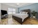 A spacious bedroom features wood flooring, a tray ceiling, and a large bed with throw pillows at 1205 Cymmer Ct., Conway, SC 29527
