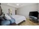 The bright bedroom has wood floors, a white ceiling fan, and a large flat-screen television at 1205 Cymmer Ct., Conway, SC 29527