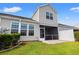 Back exterior elevation showcases a screened porch, well maintained lawn, and pleasing curb appeal at 121 Parmelee Dr. # D, Murrells Inlet, SC 29576
