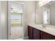 Bathroom vanity with a large mirror with an open view into a neutral carpeted bedroom at 121 Parmelee Dr. # D, Murrells Inlet, SC 29576