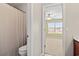 Bathroom view into bedroom featuring neutral walls and natural light from the large window at 121 Parmelee Dr. # D, Murrells Inlet, SC 29576