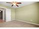 Neutral carpeted bedroom with ceiling fan and white door leading to tiled bathroom at 121 Parmelee Dr. # D, Murrells Inlet, SC 29576
