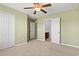 Neutral carpeted bedroom with ceiling fan, closet, and en suite tiled bathroom at 121 Parmelee Dr. # D, Murrells Inlet, SC 29576