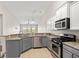 Modern kitchen features granite countertops, stainless steel appliances, and stylish gray and white cabinetry at 121 Parmelee Dr. # D, Murrells Inlet, SC 29576