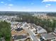 Neighborhood aerial view showcasing the home's location near trees, with a light blue sky and cozy-looking surrounding residences at 1222 Midtown Village Dr., Conway, SC 29526