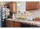 A kitchen with dark wood cabinets, double sink, stainless steel dishwasher and view to window decorations at 1222 Midtown Village Dr., Conway, SC 29526