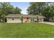 Charming brick home featuring a manicured lawn and an eye-catching orange front door at 1223 Naylor Ave., Myrtle Beach, SC 29577
