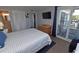 Serene bedroom features balcony access, a TV, and access to a well-lit bathroom at 1310 N Waccamaw Dr. # 102, Garden City Beach, SC 29576