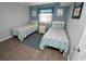 Inviting bedroom featuring twin beds with coordinating quilts, side table and wood-look floors at 1310 N Waccamaw Dr. # 102, Garden City Beach, SC 29576