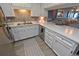 Updated kitchen features white cabinets, stainless steel appliances, mosaic backsplash, and a breakfast bar at 1310 N Waccamaw Dr. # 102, Garden City Beach, SC 29576