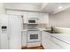 All-white kitchen equipped with modern appliances and ample counter space, featuring wood floors at 157 Egret Run Ln. # 523, Pawleys Island, SC 29585